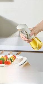Spruzzatore olio da cucina mostra una nebbia sottile sul cibo con impugnatura laterale