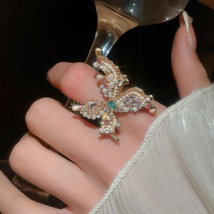 Macro detail of luxury gold butterfly ring with colorful crystals and white pearls