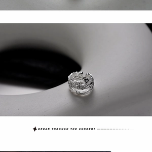 Macro detail of silver ring with irregular lava texture and small black zircon accent