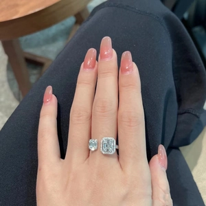 Close-up of luxury T-shape open ring with emerald cut stones on a model hand
