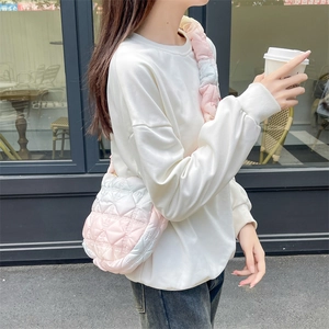 Detail of pink gradient puffer tote bag with quilted texture shown in street style