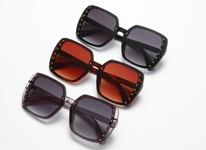 Detailed view of square sunglasses in black, tortoise, and purple with metal rivets