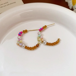 Gros plan de boucles d'oreilles perles en forme de feuille sur une assiette en céramique