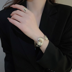 Detail showing polished liquid metal style silver cuff bracelet and matching ring on model