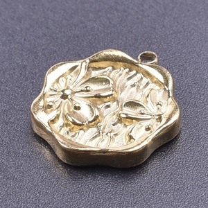 Detail of flower-shaped 18k gold plated stainless steel pendant with bee relief