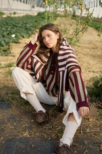 Detail view of retro red and green striped knit sweater with matching scarf in farm setting