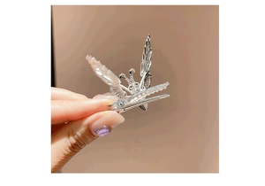 Detailed view of silver butterfly hair clip with hollow wings and metal alligator grip