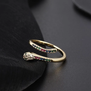 Macro detail of a golden snake ring featuring colorful zircons and intricate eye carving