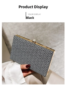 Detail of acrylic clutch with black and white wavy pattern and golden rhinestone clasp