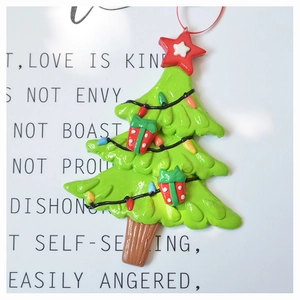 Close-up of green Christmas tree clay ornament with red star detail and hanging string