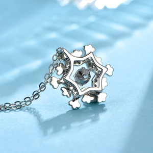 Macro shot of silver snowflake pendant necklace featuring a central light blue zircon stone