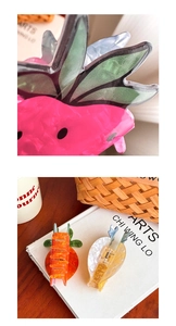Close-up of strawberry and carrot hair claws with smooth texture and metal spring mechanism