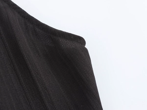 Close-up of elegant black knitted halter dress showing textured fabric and stitching