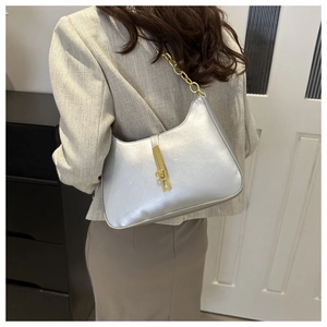 Detail of silver metallic hobo bag with gold piston lock and chunky chain shoulder strap