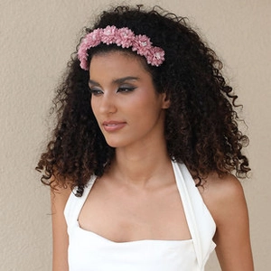 Detailed view of handmade pink fabric flower headband on model with artistic floral tassels