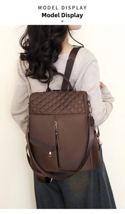 Detail of dark brown nylon backpack with quilted diamond stitching and gold zippers