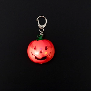 Close-up of glowing Halloween pumpkin keychain with LED light and silver metal ring