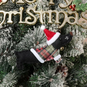 Close-up of a felt dachshund dog Christmas ornament with a plaid sweater and hat