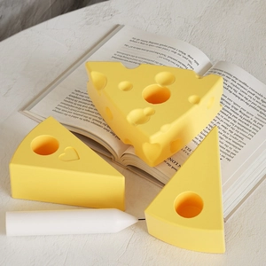 Dettaglio del portacandele a forma di formaggio con cuore in rilievo su sfondo libro
