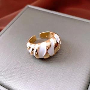 Macro detail of French vintage gold ring with white enamel and spiral texture