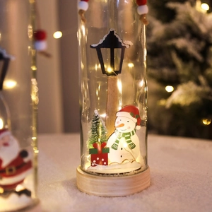 Christmas LED glass wishing bottle with snowman and tree on a warm wooden base