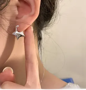 Vista macro di un orecchino a stella in argento sterling 3D con finitura a specchio