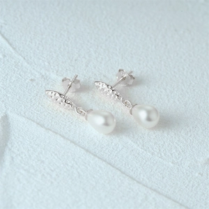 Macro shot of S925 sterling silver pearl earring with textured finish and drop shape