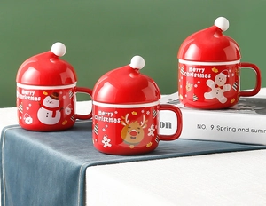 Detailed view of red ceramic Christmas mugs with creative Santa hat lids and festive patterns