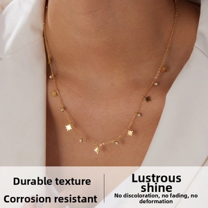 Détail du collier doré avec pendentifs étoile et zircons porté sur le cou du mannequin
