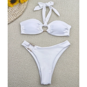 Two-piece white halter bikini set with decorative gold rings on a textured background