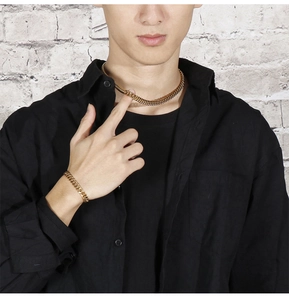 Detail view of 8mm gold Cuban link chain necklace and bracelet set on a male model