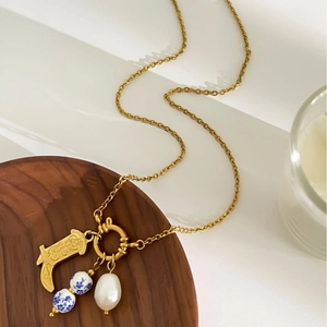 Vintage gold boots necklace with blue porcelain beads and baroque pearl on wood