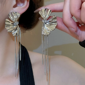 Detail of silver flower tassel earrings with sparkling crystals and long metal chains