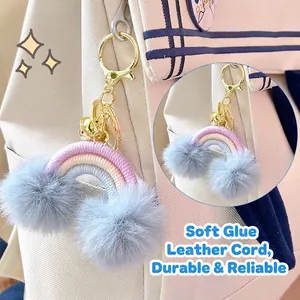 Rainbow bohemian keychain with faux fur pom poms on a white backpack accessory