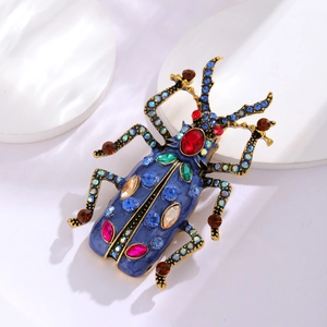 Dettaglio della spilla a scarabeo vintage con smalto blu e strass colorati brillanti