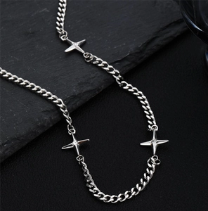 Detail of silver star pendant necklace with cubic zirconia on textured background