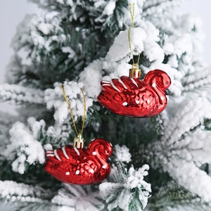 Par de adornos navideños de cisne rojo con cordones dorados en ramas nevadas