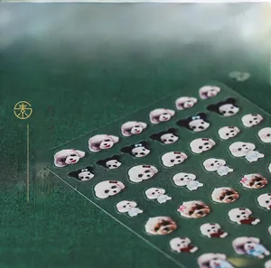 Macro detail of 3D cute dog nail stickers with various puppy breeds on green background