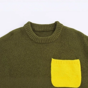 Olive green knit crewneck sweater with a contrasting yellow pocket in a flat lay view