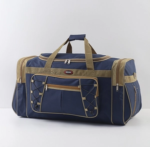 Detail view of large blue waterproof travel duffel bag with khaki handles and front pocket