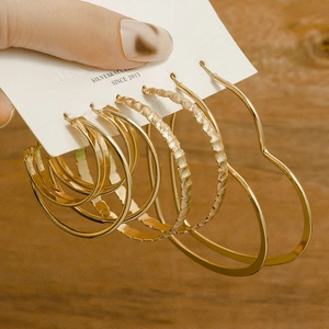 Detailed view of assorted gold hoop earrings and heart shapes on a silver needle card