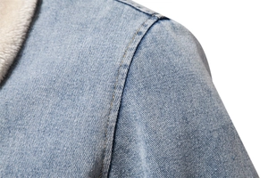 Detail view of denim jacket shoulder stitching and soft fleece collar texture