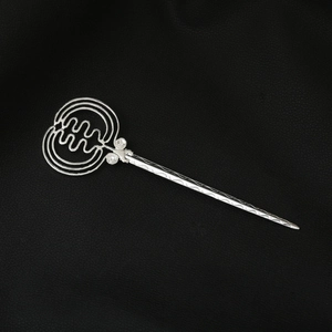 Close-up of silver geometric hollow hair pin with ripple texture on black background