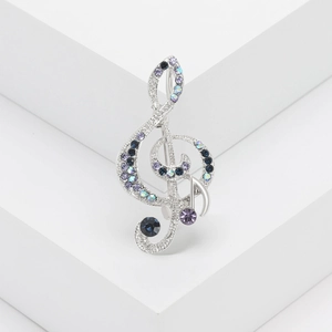 Elegant musical note brooch with multicolor rhinestones on a white display stand
