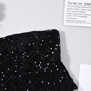 Macro shot of high-quality black sequin fabric texture with shimmering light reflections