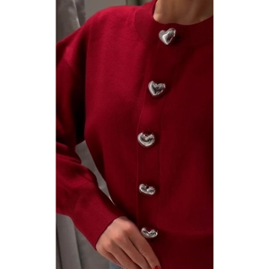 Red knit cardigan featuring unique silver heart-shaped buttons and a round neckline