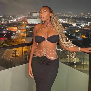 Detail van zilveren meerlaagse ketting sieraden en zwarte bandeau top op een model 's nachts