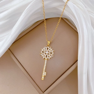 Elegant gold hollow flower key necklace with diamonds on luxury silk background