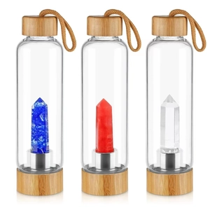 Detailed view of glass water bottles with bamboo lids and natural crystal columns inside