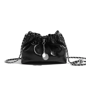 Detail of black pleated cloud bucket bag with pearl pendant and chain strap